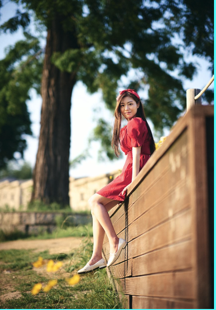 Girl sitting on wooden fence