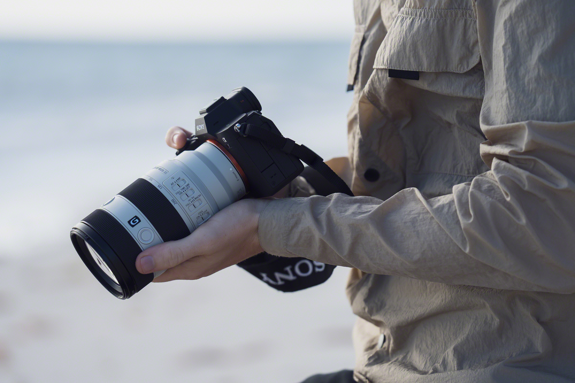 Man carrying a camera with the Sony FE 70-200mm F4 Macro G OSS II lens outdoors