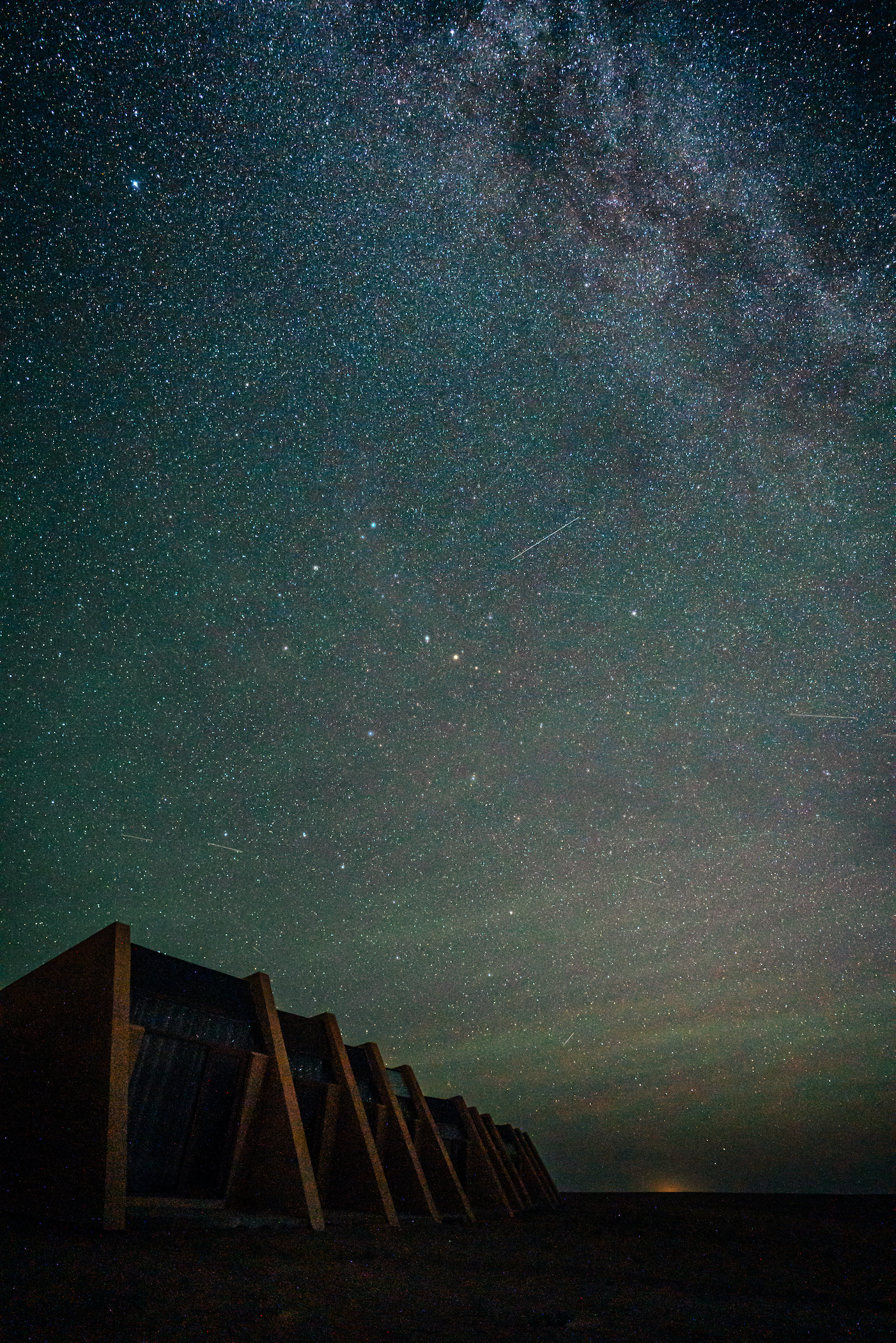 Wide shot of the lodges under a vast, starry night sky