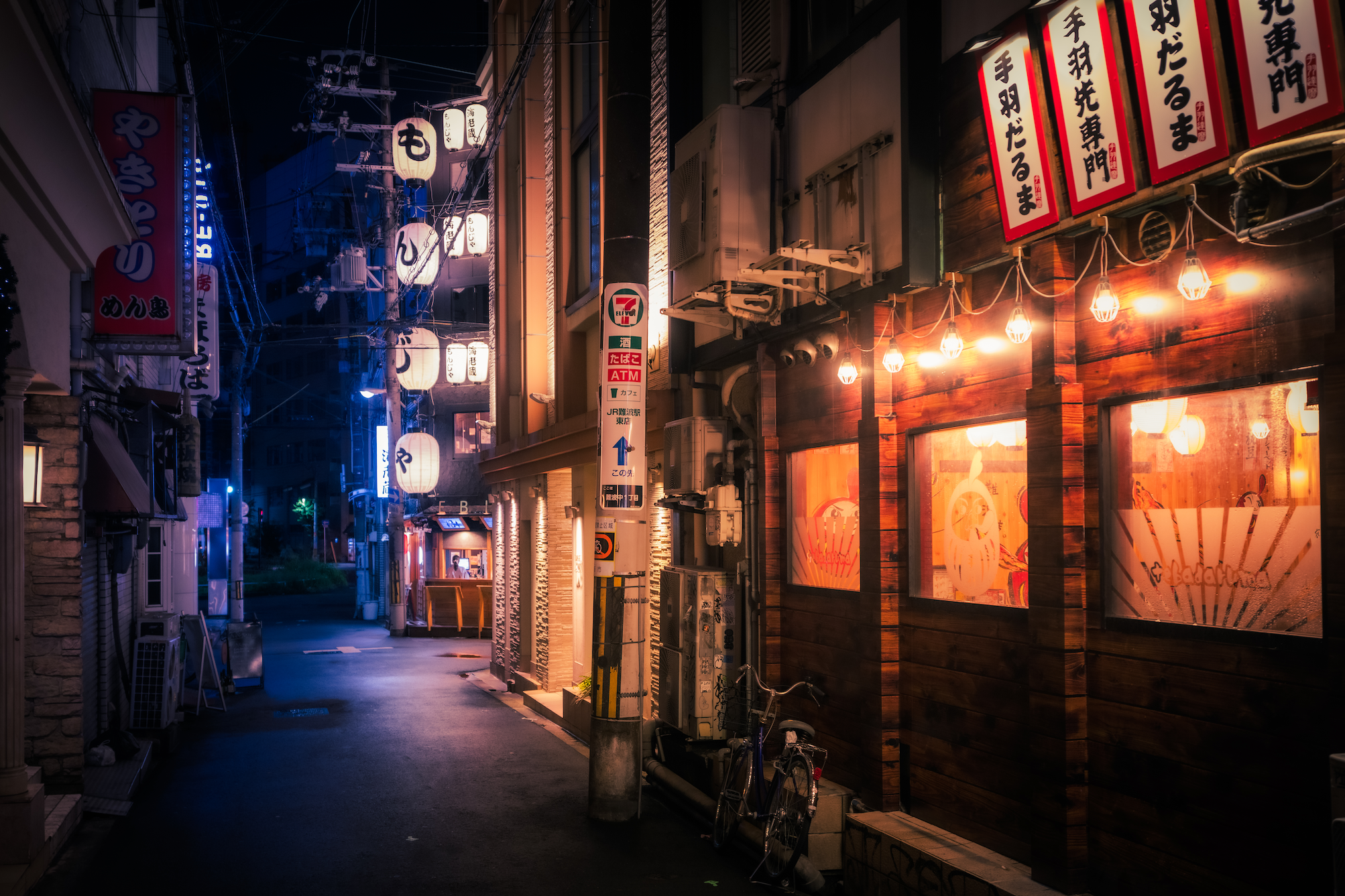 Quiet alley in Osaka with street lights and eateries at night