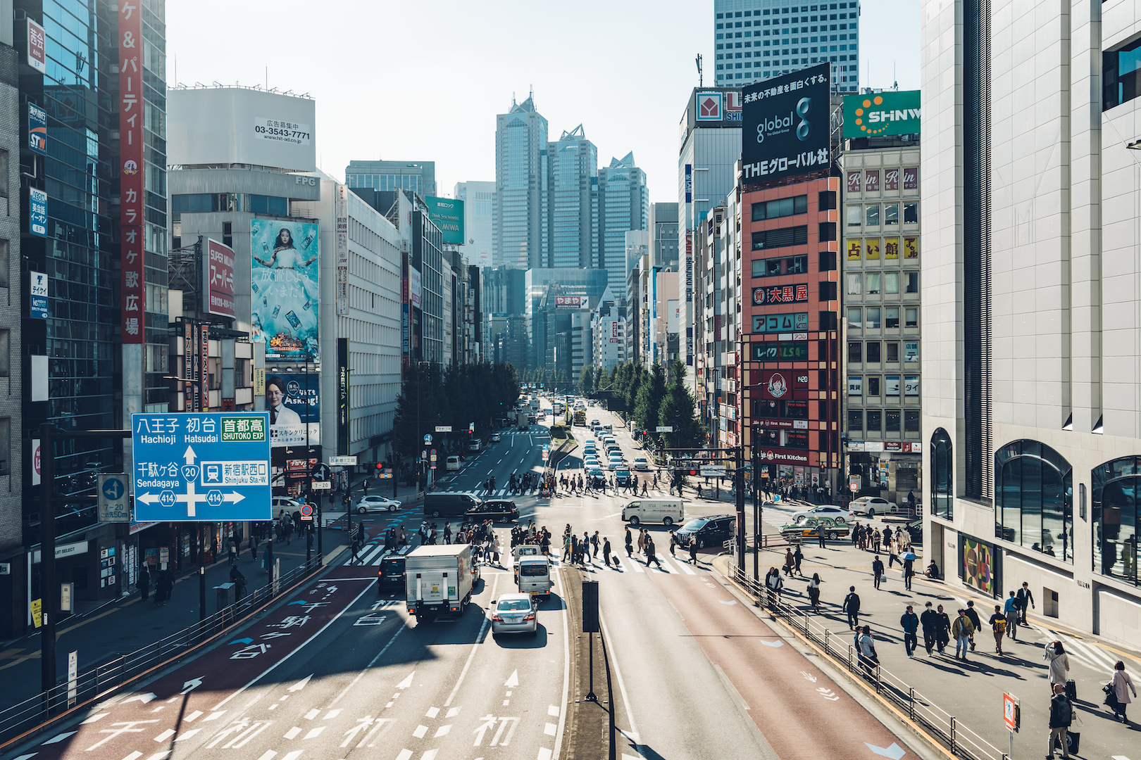 View of a busy Shinjuku street with cars and pedestrians from a bridge 